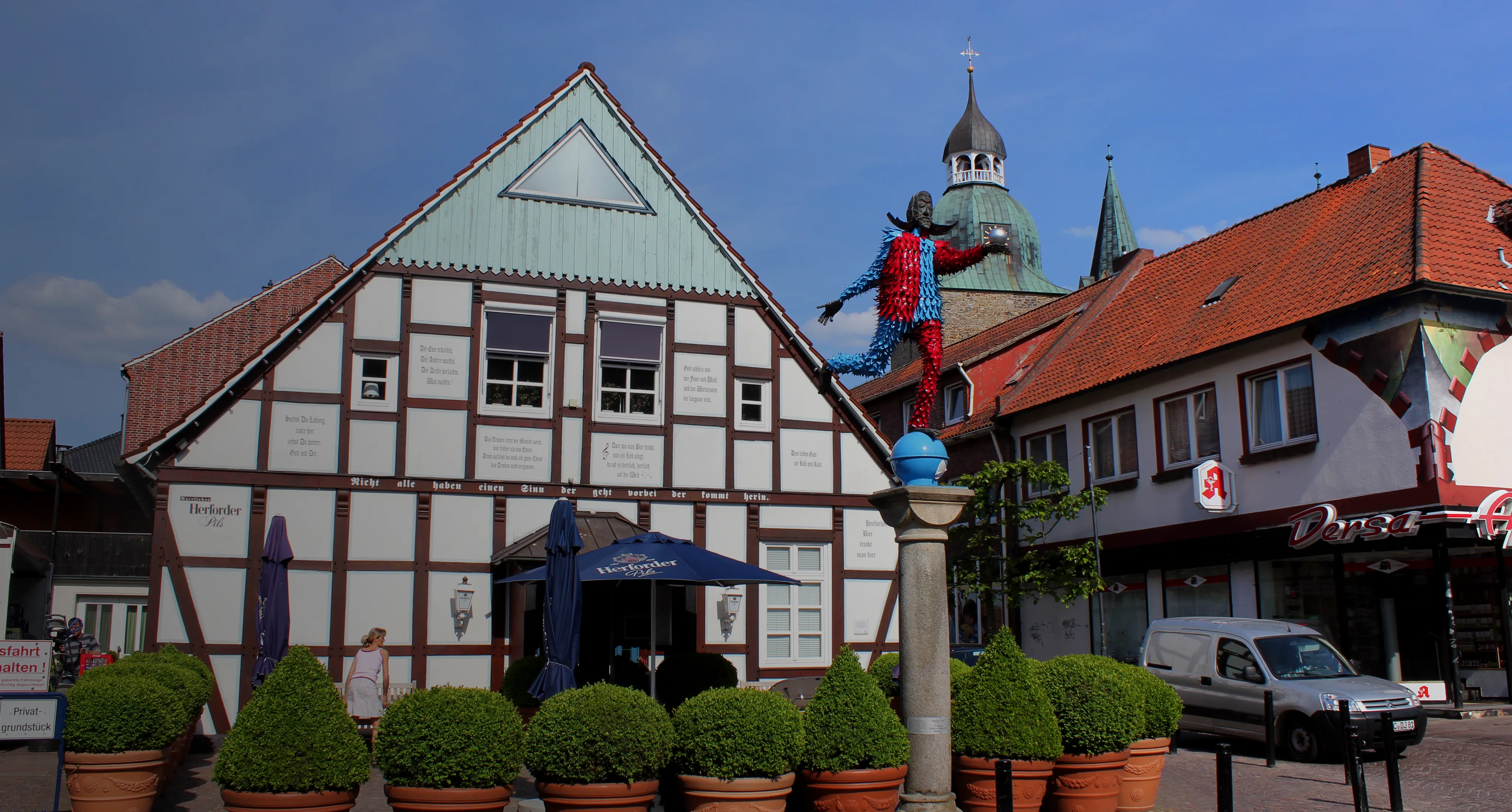 Bannerbild Fachwerkhaus in der Innenstadt von Damme mit Statue und Apotheke im Hintergrund